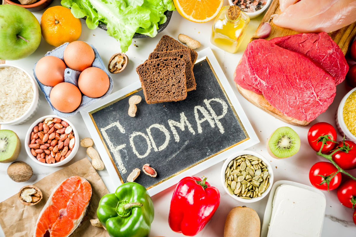 FODMAP chalkboard sign surrounded by fruits, vegetables, grains and eggs