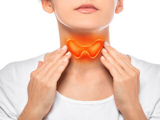 Woman touching her neck with an illustrated thyroid gland highlighted