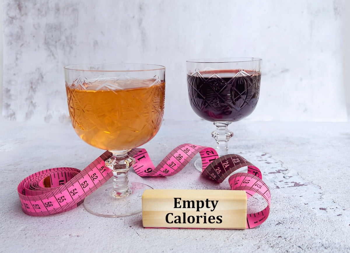 Glasses of beer and red wine with a measuring tape and an empty calories tag
