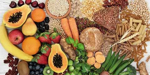Variety of high-fiber whole foods including fruits, vegetables, legumes and grains