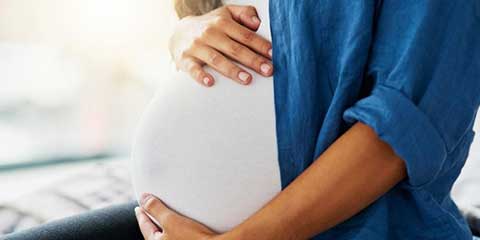 Pregnant woman holding her belly