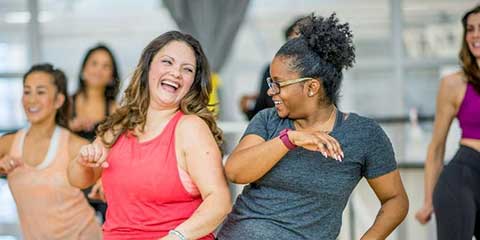 Group of women laughing together during an outdoor workout