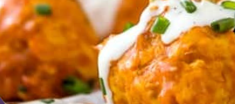Baked buffalo chicken meatballs topped with green onions