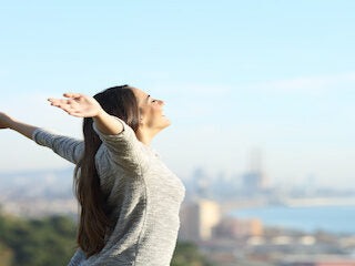 Woman with arms open enjoying the view over a city skyline