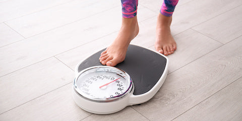 Feet stepping onto a bathroom scale