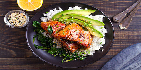Bowl of salmon, rice and avocado with fresh greens