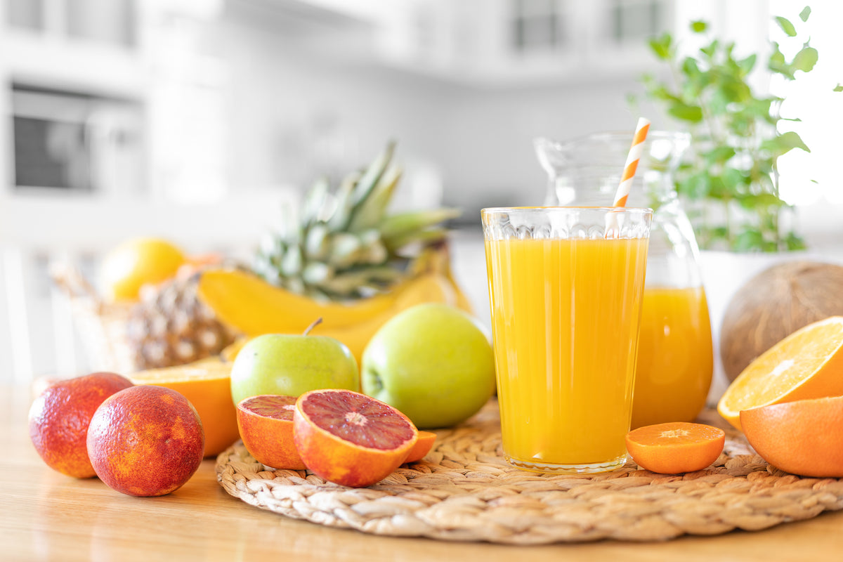 Fresh fruit and a glass of orange juice on a table
