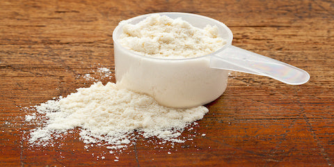 What Type of Protein Powder Is Best - a scoop of protein powder on a wooden table.