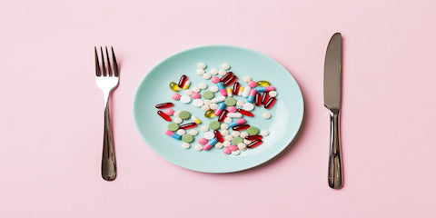 Small plate of food with a fork and knife on a pink tablecloth