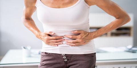 Woman holding her stomach in discomfort