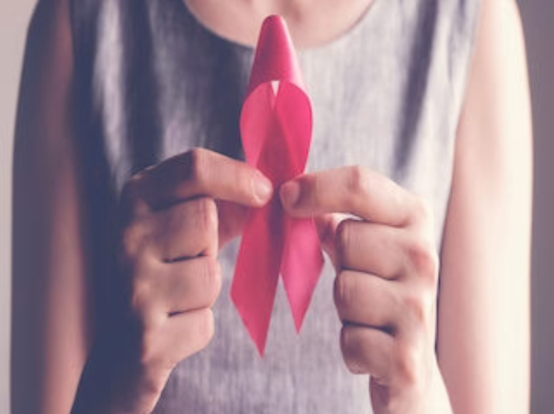Woman holding a pink breast cancer awareness ribbon