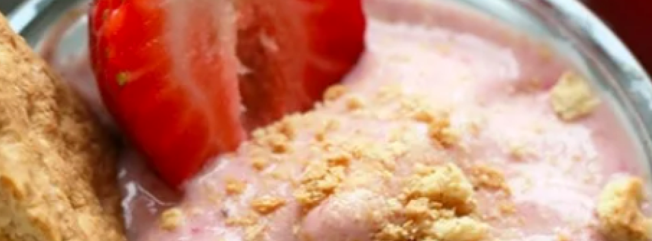 Strawberry cheesecake protein shake topped with a fresh strawberry
