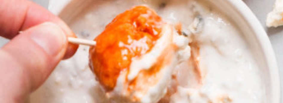 Celery stick dipped in creamy blue cheese dip