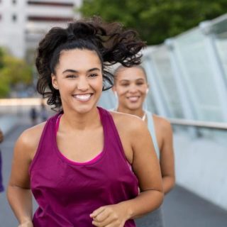 Smiling woman exercising outdoors with a friend