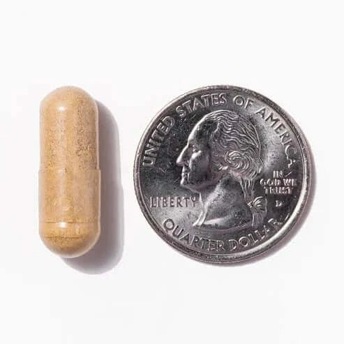 Capsule next to a quarter, a01f251d-53ef-437d-a6c0-7f367e38b9ec