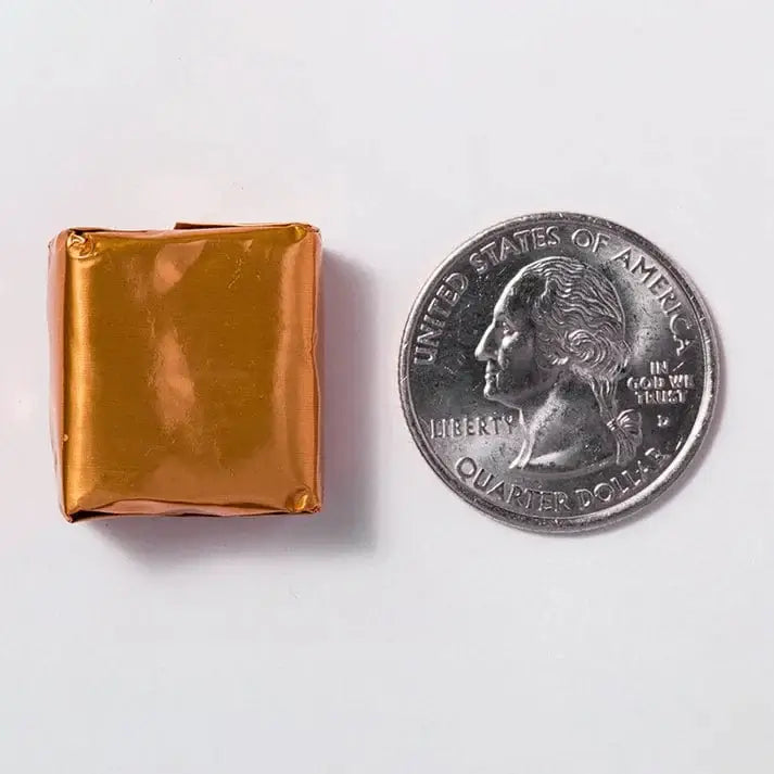 Calcium Chew | Sea Salted Caramel soft chew beside a quarter for size comparison.
