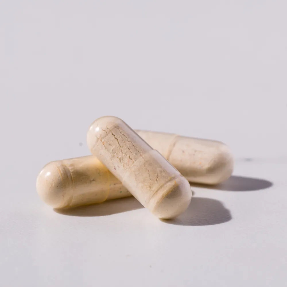Three supplement capsules on a light background